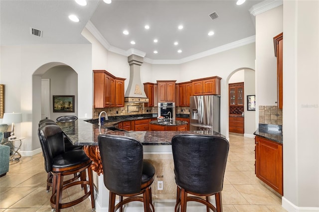 3986 SE 43rd Cir, Ocala, FL 34480 - kitchen with stainless steel appliances, a kitchen island with sink, arched walkways, light tile patterned flooring, and a peninsula