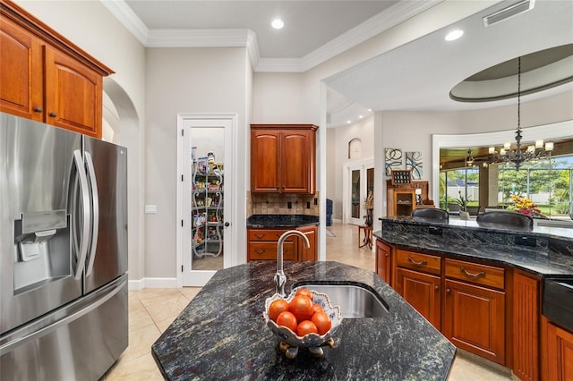 3986 SE 43rd Cir, Ocala, FL 34480 - kitchen with stainless steel refrigerator with ice dispenser, tasteful backsplash, light tile patterned floors, ornamental molding, and dark stone countertops