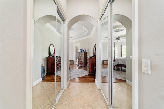 3986 SE 43rd Cir, Ocala, FL 34480 - corridor featuring ornamental molding, light tile patterned flooring, arched walkways, and a tray ceiling