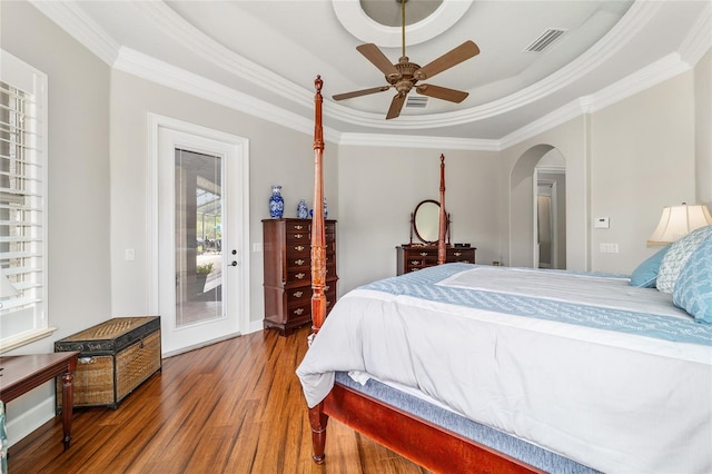 3986 SE 43rd Cir, Ocala, FL 34480 - bedroom with a tray ceiling, access to exterior, wood finished floors, ornamental molding, and arched walkways