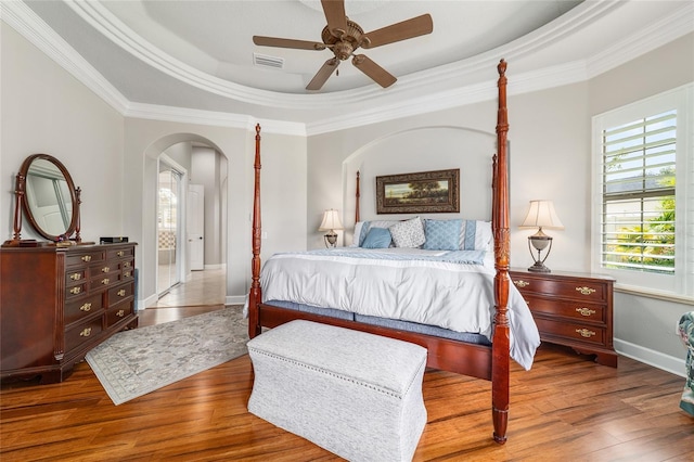 3986 SE 43rd Cir, Ocala, FL 34480 - bedroom with arched walkways, crown molding, wood finished floors, a raised ceiling, and ceiling fan
