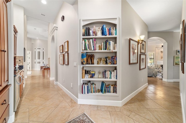 3986 SE 43rd Cir, Ocala, FL 34480 - hall with arched walkways, built in shelves, and light tile patterned floors