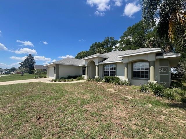 8100 SW 56th Ter, Ocala, FL 34476 - ranch-style home with stucco siding, an attached garage, concrete driveway, and a front yard