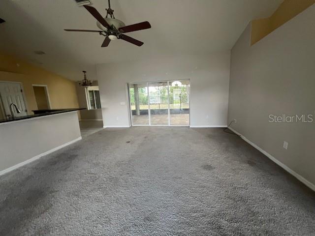 8100 SW 56th Ter, Ocala, FL 34476 - unfurnished living room with lofted ceiling, ceiling fan, carpet, and baseboards