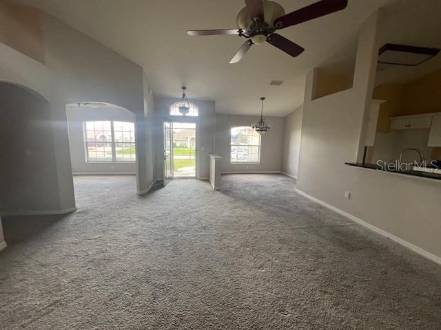 8100 SW 56th Ter, Ocala, FL 34476 - carpeted empty room with baseboards, a ceiling fan, a chandelier, and high vaulted ceiling
