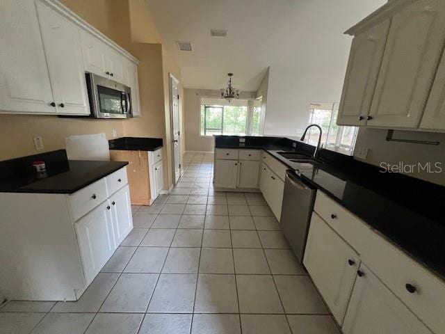 8100 SW 56th Ter, Ocala, FL 34476 - kitchen with stainless steel appliances, a sink, dark countertops, light tile patterned flooring, and a chandelier