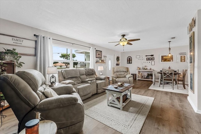 460 E Haines Blvd, Lake Alfred, FL 33850 - living room with a ceiling fan, wood finished floors, baseboards, and a textured ceiling