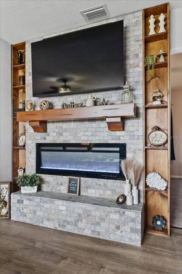 460 E Haines Blvd, Lake Alfred, FL 33850 - detailed view of a fireplace, wood finished floors, a ceiling fan, built in shelves, and a textured ceiling