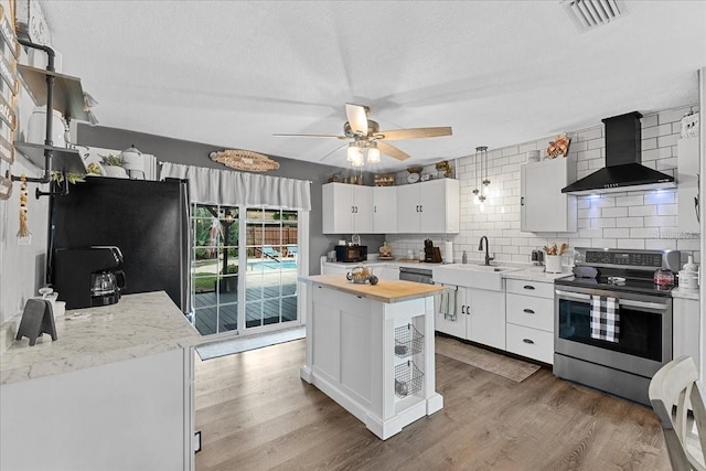 460 E Haines Blvd, Lake Alfred, FL 33850 - kitchen featuring stainless steel electric range, wall chimney exhaust hood, freestanding refrigerator, a sink, and tasteful backsplash