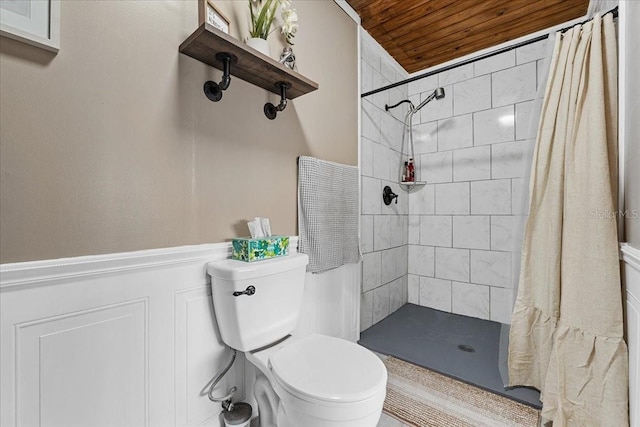 460 E Haines Blvd, Lake Alfred, FL 33850 - full bathroom featuring wooden ceiling, toilet, a tile shower, wainscoting, and a decorative wall