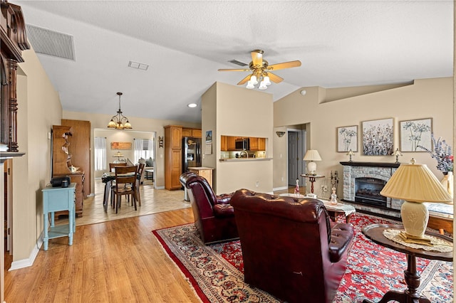 8732 SW 60th Cir, Ocala, FL 34476 - living room featuring lofted ceiling, ceiling fan, light wood-style floors, a fireplace, and baseboards