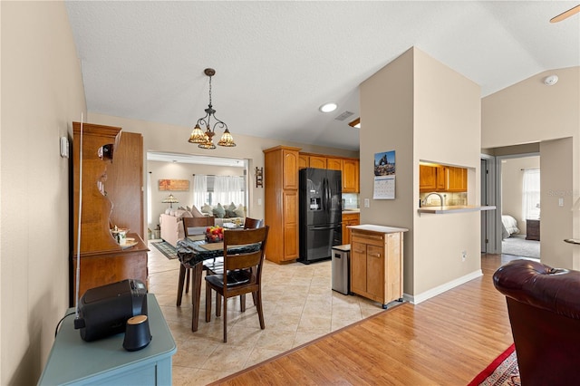 8732 SW 60th Cir, Ocala, FL 34476 - kitchen featuring black refrigerator with ice dispenser, open floor plan, lofted ceiling, a chandelier, and light countertops