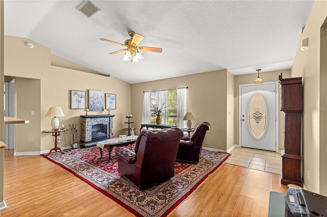 8732 SW 60th Cir, Ocala, FL 34476 - living area with ceiling fan, lofted ceiling, light wood-style flooring, a fireplace, and baseboards