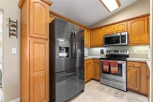 8732 SW 60th Cir, Ocala, FL 34476 - kitchen with appliances with stainless steel finishes, lofted ceiling, decorative backsplash, light countertops, and brown cabinets