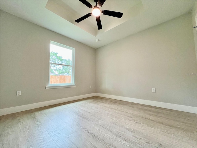 8289 SE 159th Ln, Summerfield, FL 34491 - spare room with wood finished floors, a ceiling fan, and a tray ceiling