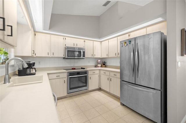 11326 SE 175th Pl, Summerfield, FL 34491 - kitchen with stainless steel appliances, a sink, light countertops, light tile patterned floors, and decorative backsplash