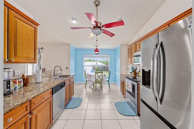 63 Walnut Crse, Ocala, FL 34480 - kitchen featuring appliances with stainless steel finishes, a sink, brown cabinetry, ceiling fan, and stone countertops