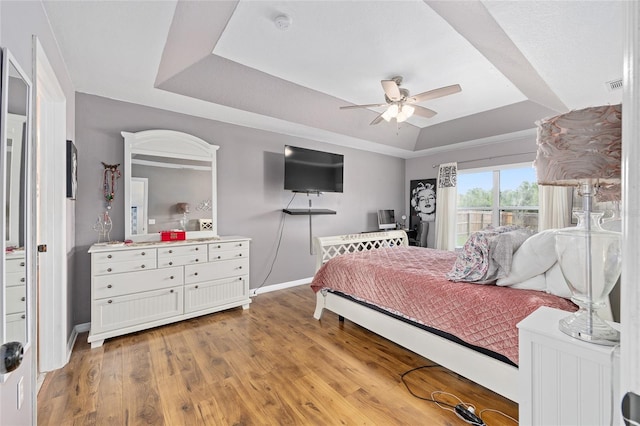 63 Walnut Crse, Ocala, FL 34480 - bedroom featuring a tray ceiling, baseboards, light wood-style flooring, and ceiling fan