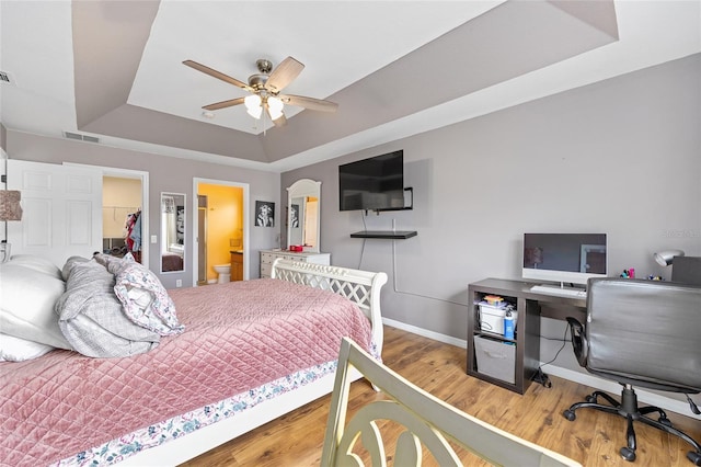 63 Walnut Crse, Ocala, FL 34480 - bedroom featuring a raised ceiling, baseboards, a spacious closet, wood finished floors, and a desk