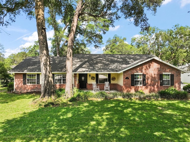 986 SE 57th Ave, Ocala, FL 34480 - single story home featuring brick siding, covered porch, a front lawn, and a shingled roof