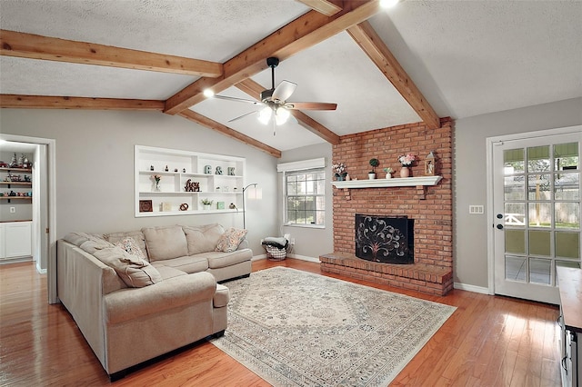986 SE 57th Ave, Ocala, FL 34480 - living room with a ceiling fan, light wood-type flooring, a textured ceiling, baseboards, and a brick fireplace