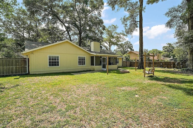 986 SE 57th Ave, Ocala, FL 34480 - back of house with a chimney, a sunroom, and a fire pit