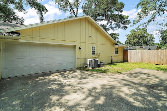 986 SE 57th Ave, Ocala, FL 34480 - view of side of property featuring central AC, concrete driveway, and an attached garage