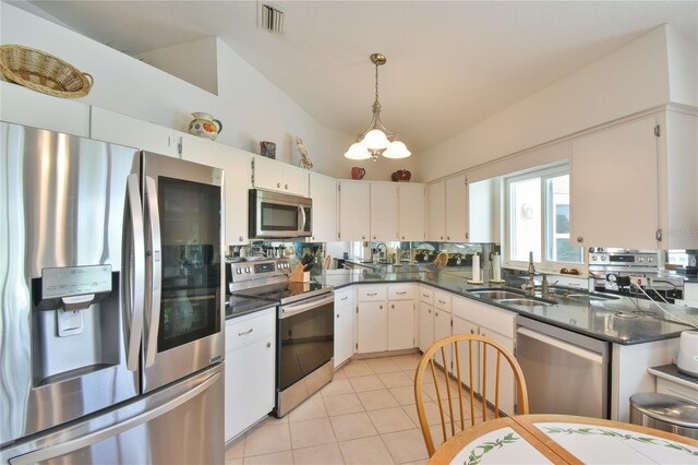2478 NW 50th Ave, Ocala, FL 34482 - kitchen featuring appliances with stainless steel finishes, dark countertops, vaulted ceiling, light tile patterned floors, and pendant lighting