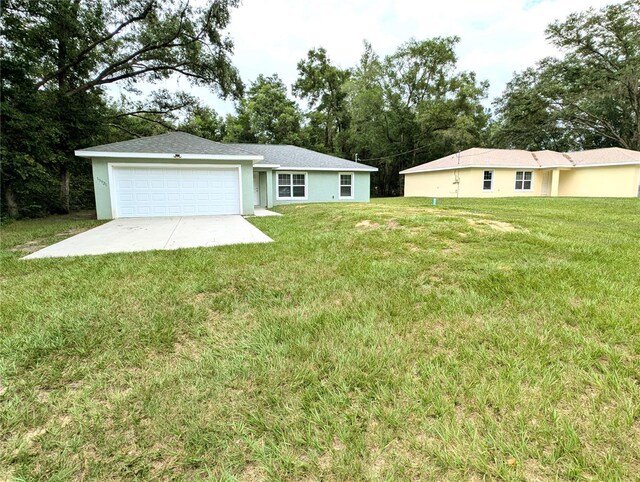 13921 SW 108th Ln, Dunnellon, FL 34432 - view of grassy yard featuring a garage and concrete driveway