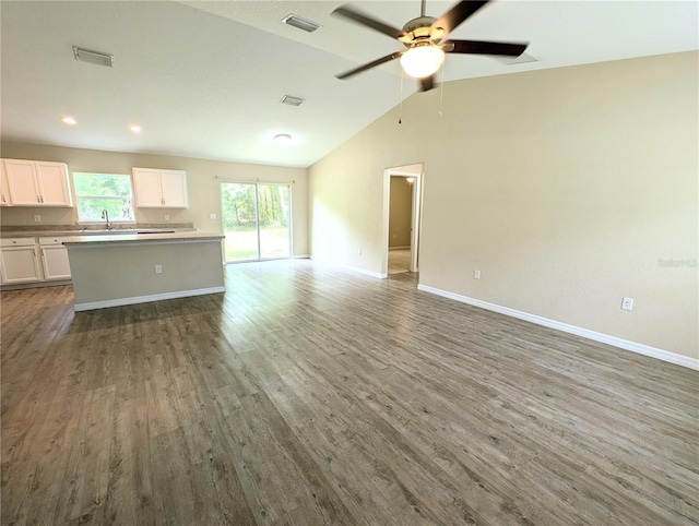 13921 SW 108th Ln, Dunnellon, FL 34432 - unfurnished living room featuring wood finished floors, baseboards, a ceiling fan, vaulted ceiling, and a sink