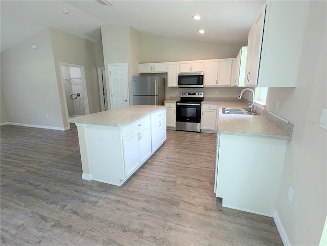 13921 SW 108th Ln, Dunnellon, FL 34432 - kitchen featuring appliances with stainless steel finishes, lofted ceiling, a sink, a kitchen island, and light wood finished floors