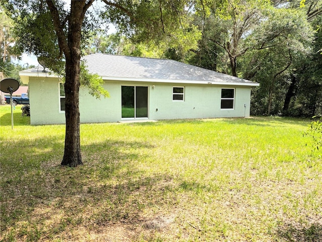 13921 SW 108th Ln, Dunnellon, FL 34432 - rear view of house featuring a lawn and stucco siding