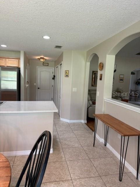 16023 SW 14th Avenue Rd, Ocala, FL 34473 - kitchen featuring stainless steel refrigerator, a textured ceiling, arched walkways, light tile patterned floors, and recessed lighting