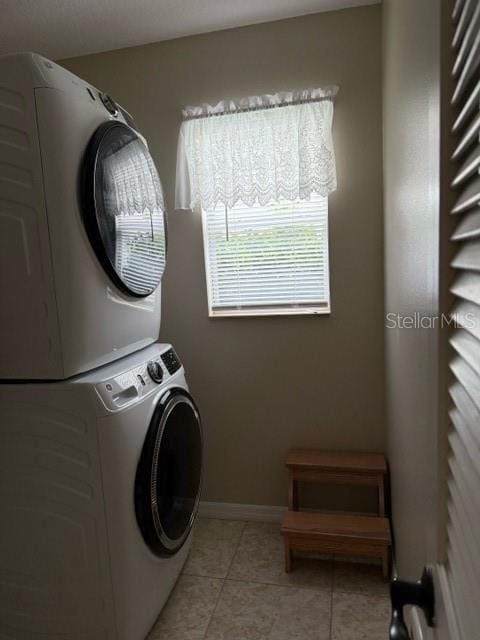 16023 SW 14th Avenue Rd, Ocala, FL 34473 - washroom with stacked washing machine and dryer, light tile patterned floors, and baseboards