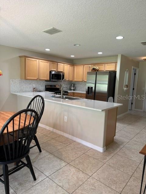 16023 SW 14th Avenue Rd, Ocala, FL 34473 - kitchen featuring appliances with stainless steel finishes, a sink, light countertops, recessed lighting, and a textured ceiling
