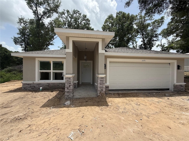 3696 SE 139th Ln, Summerfield, FL 34491 - view of front of house featuring stone siding, stucco siding, a garage, and roof with shingles