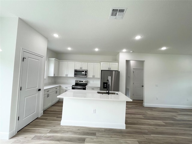 142 Guava Pass, Ocklawaha, FL 32179 - kitchen with appliances with stainless steel finishes, baseboards, a kitchen island with sink, light wood finished floors, and recessed lighting