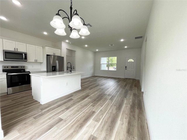 142 Guava Pass, Ocklawaha, FL 32179 - kitchen with stainless steel appliances, a sink, light countertops, light wood-style floors, and a chandelier