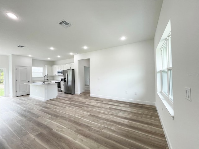 142 Guava Pass, Ocklawaha, FL 32179 - unfurnished living room with a sink, baseboards, light wood-style flooring, and recessed lighting