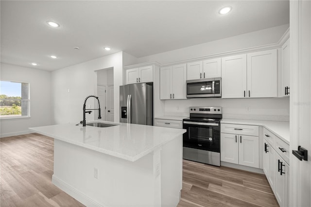 75 Guava Ter, Ocklawaha, FL 32179 - kitchen with appliances with stainless steel finishes, light wood-style floors, white cabinetry, a center island with sink, and recessed lighting