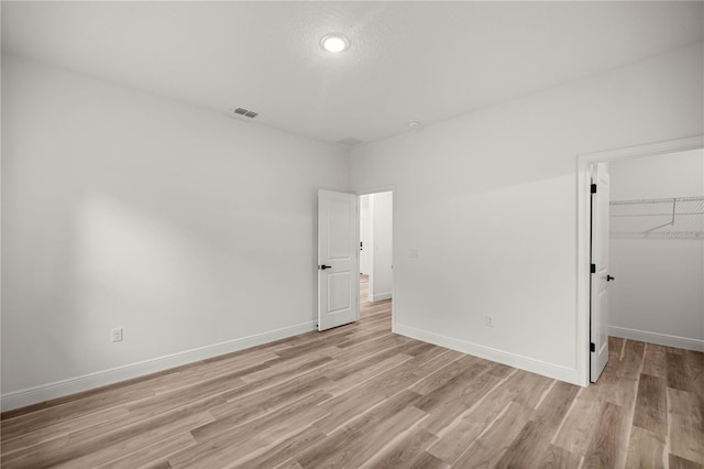 75 Guava Ter, Ocklawaha, FL 32179 - unfurnished bedroom with light wood-style flooring, a closet, and a walk in closet