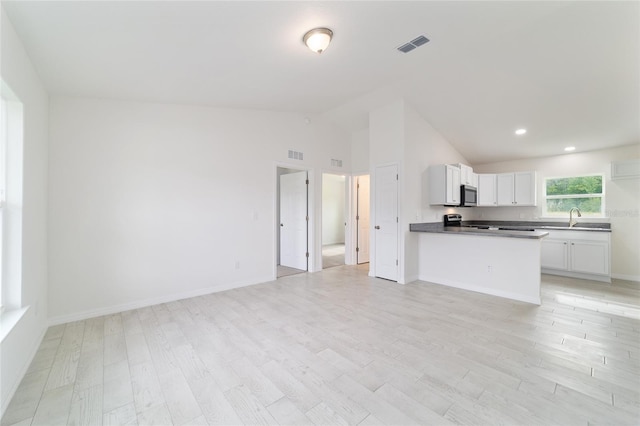37 Teak Run, Ocala, FL 34472 - kitchen with stainless steel microwave, open floor plan, light wood-style flooring, high vaulted ceiling, and recessed lighting