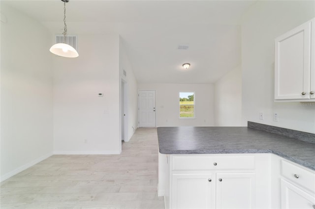 37 Teak Run, Ocala, FL 34472 - kitchen featuring dark countertops, a peninsula, white cabinetry, light wood-type flooring, and pendant lighting