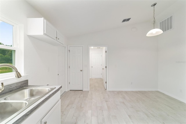 37 Teak Run, Ocala, FL 34472 - kitchen featuring light wood-style floors, white cabinets, decorative light fixtures, vaulted ceiling, and light countertops