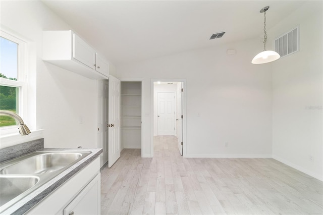 37 Teak Run, Ocala, FL 34472 - kitchen featuring light wood-style floors, white cabinetry, decorative light fixtures, lofted ceiling, and light countertops