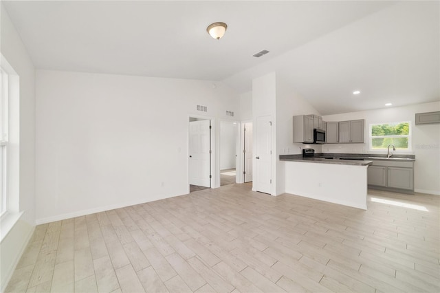 14690 SW 24th Pl, Ocala, FL 34481 - kitchen featuring gray cabinets, lofted ceiling, open floor plan, range with electric cooktop, and stainless steel microwave