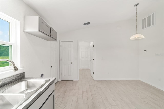 14690 SW 24th Pl, Ocala, FL 34481 - kitchen featuring light wood finished floors, pendant lighting, vaulted ceiling, gray cabinets, and light countertops