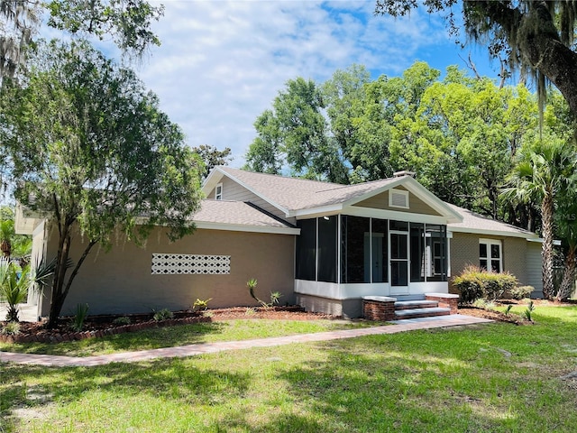 4609 NE 7th St, Ocala, FL 34470 - view of front of home with a sunroom, a front yard, and a shingled roof