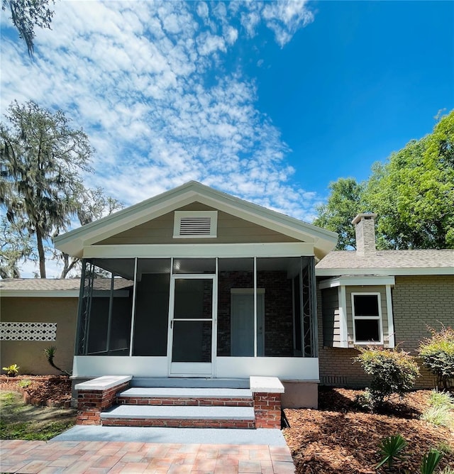4609 NE 7th St, Ocala, FL 34470 - view of front of house with a sunroom, brick siding, and a chimney