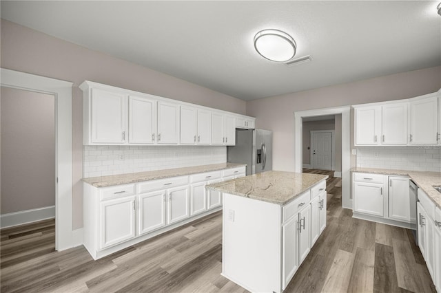 4609 NE 7th St, Ocala, FL 34470 - kitchen with appliances with stainless steel finishes, backsplash, white cabinetry, and wood finished floors